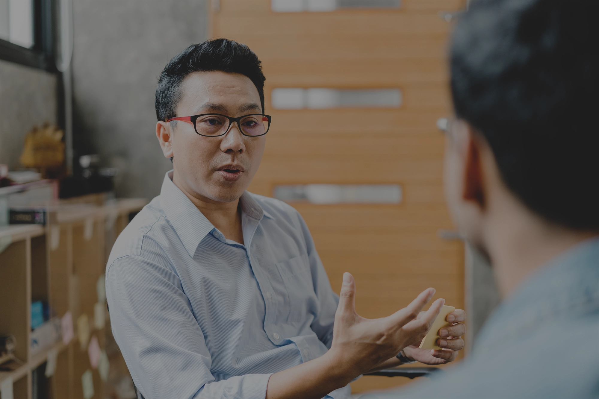 Photo of rows of books in a library with marble busts.